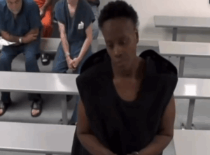 Individual standing in front of camera in what appears to be a judicial environment
