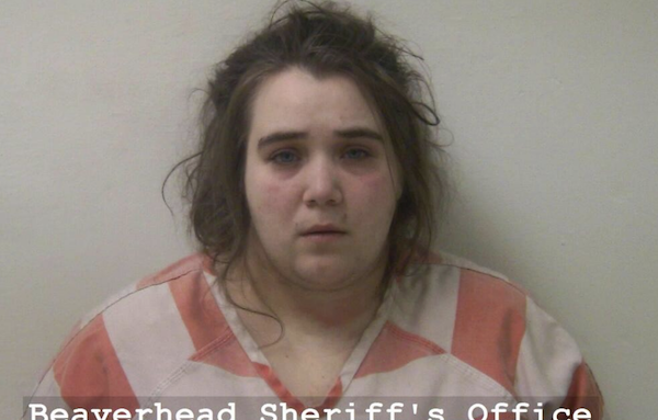 Booking photo of a woman with disheveled hair and a solemn expression, wearing a jail-issued striped shirt, with "Beaverhead Sheriff's Office Number: 20388" displayed at the bottom.