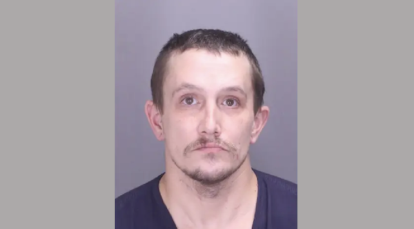 Booking photo showing a man with a light complexion, short hair, and a trimmed goatee, looking directly at the camera.