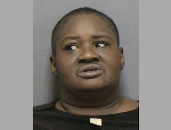 Portrait-style mugshot image showing a person with a neutral expression, facing forward with their eyes turned to the left.