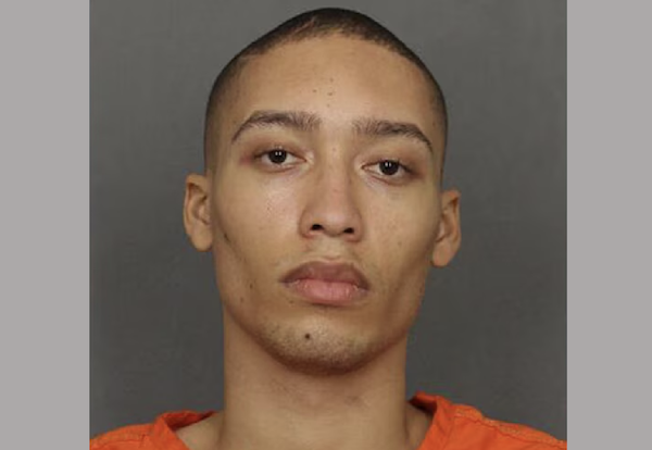 Close-up mugshot-style image of a young man with closely cropped hair and a neutral expression.