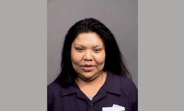 Woman with dark shoulder-length hair faces the camera in a plain portrait photo.