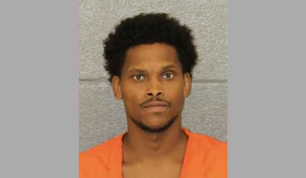 Front-facing mugshot of a man in orange clothing looking directly at the camera with a neutral expression.